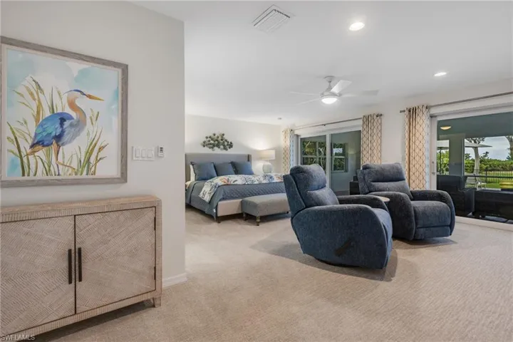 Bedroom with ceiling fan, light colored carpet, and access to outside