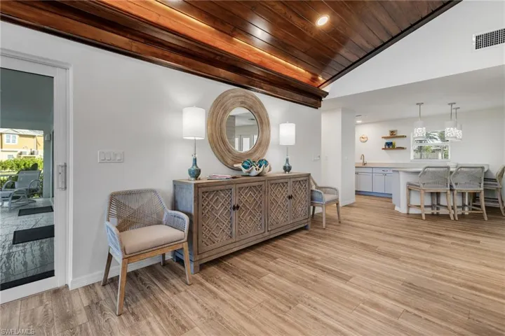 Living area with wood ceiling, high vaulted ceiling, and light hardwood / wood-style flooring