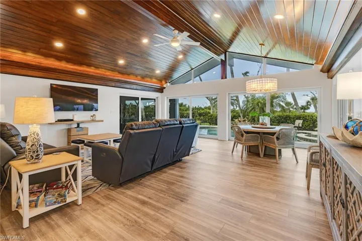 Living room featuring a healthy amount of sunlight, light wood-type flooring, and wooden ceiling