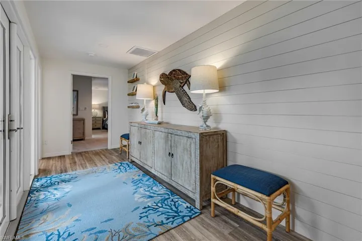 Hall featuring wood walls and light hardwood / wood-style flooring