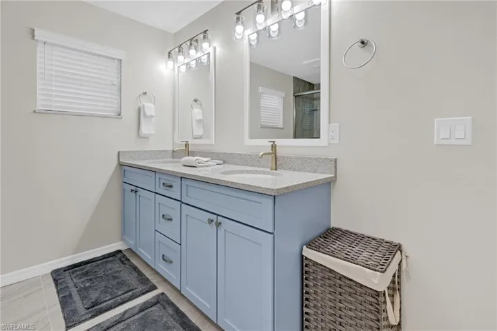 Bathroom featuring tile patterned flooring, vanity, and an enclosed shower