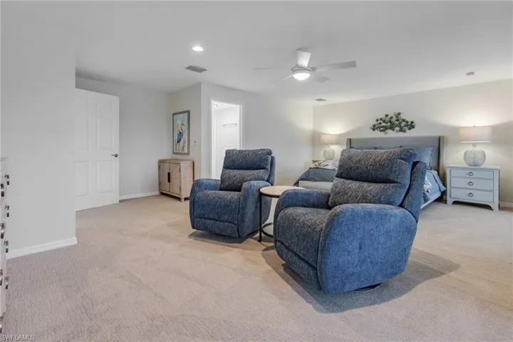 Bedroom with light colored carpet and ceiling fan