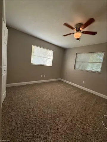 Spare room featuring carpet floors and a ceiling fan