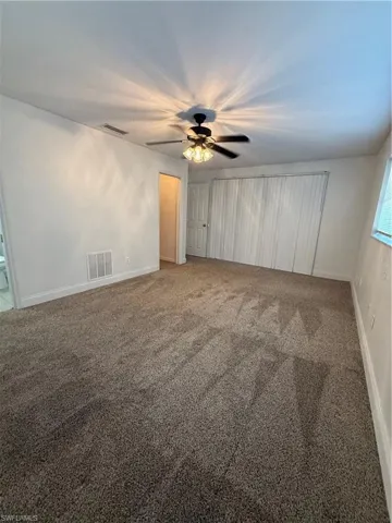 Unfurnished bedroom with carpet floors, ceiling fan, and a closet