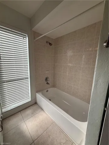 Full bath featuring shower / washtub combination and light tile patterned flooring