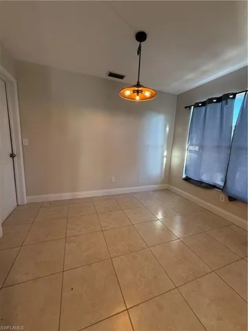 Empty room with light tile patterned floors