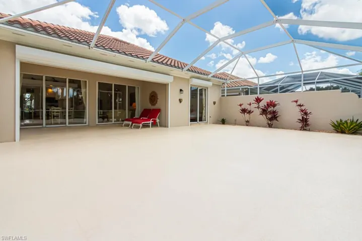 Rear view of property with a lanai, a tile roof, a patio, and stucco siding