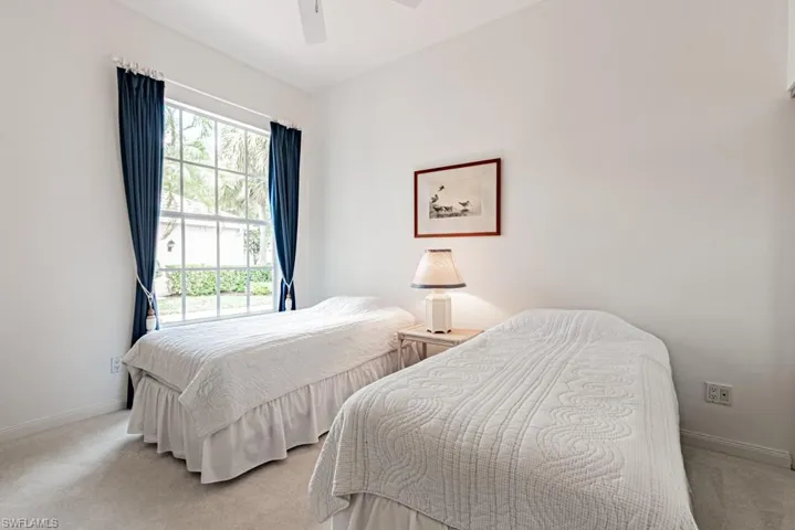 Bedroom with baseboards, a ceiling fan, and light carpet