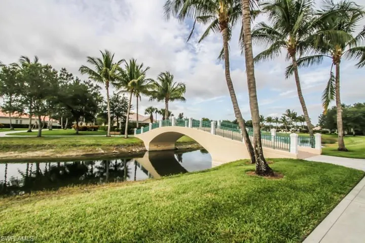 View of property's community with a yard, fence, and a water view