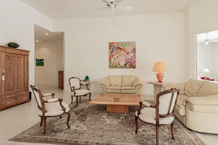 Living room with light tile patterned floors and a ceiling fan