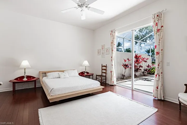 Bedroom with baseboards, access to exterior, hardwood / wood-style floors, and a ceiling fan
