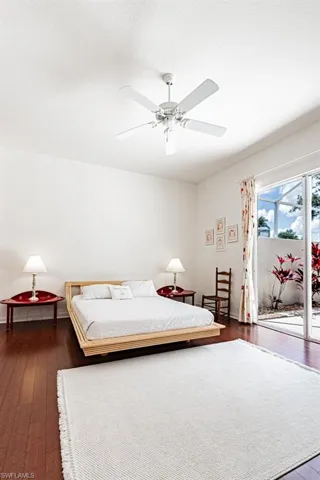 Bedroom featuring a textured ceiling, access to exterior, ceiling fan, and dark wood-style floors