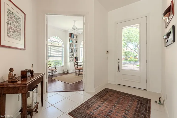 Entryway with light tile patterned flooring, ceiling fan, and baseboards