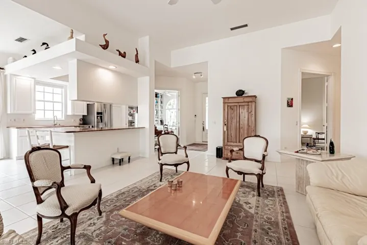 Living room with light tile patterned floors, ceiling fan, recessed lighting, and visible vents