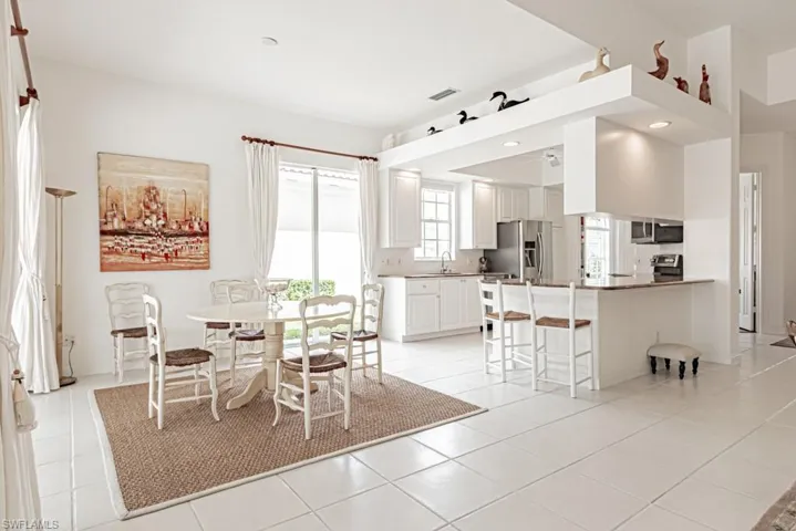 Dining space featuring light tile patterned floors and visible vents