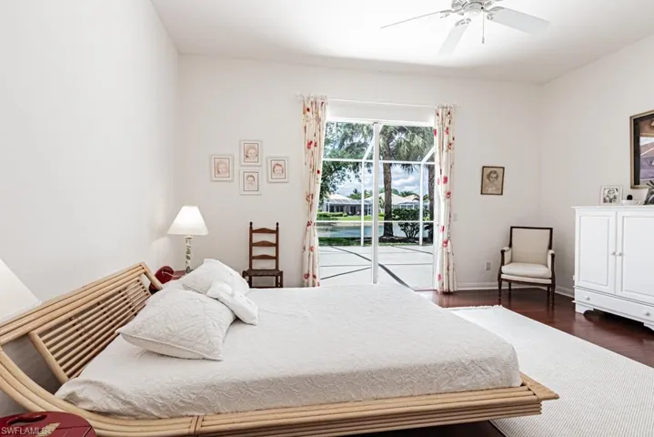 Bedroom featuring baseboards, access to exterior, a ceiling fan, and dark wood finished floors
