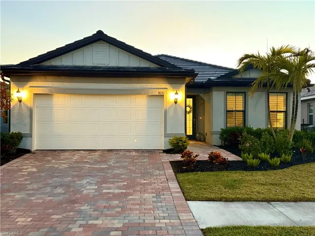 View of front of home with a yard and a garage