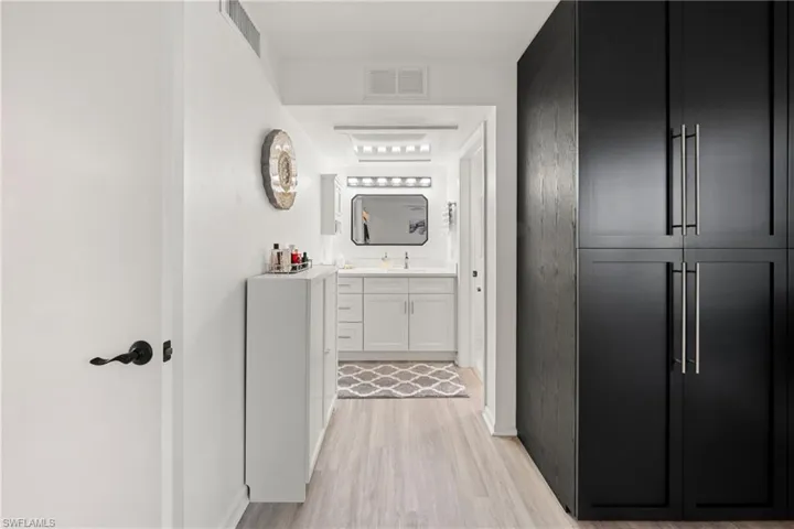 Corridor featuring light wood-type flooring and baseboards