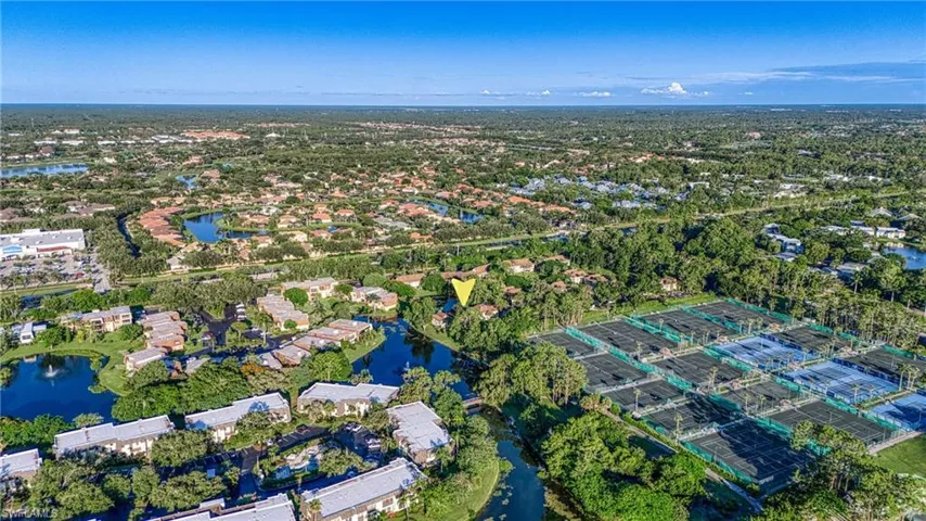 Aerial view of property's location featuring a nearby body of water and nearby suburban area