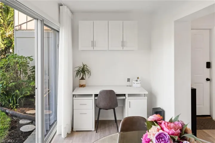 Office featuring built in desk and light wood finished floors