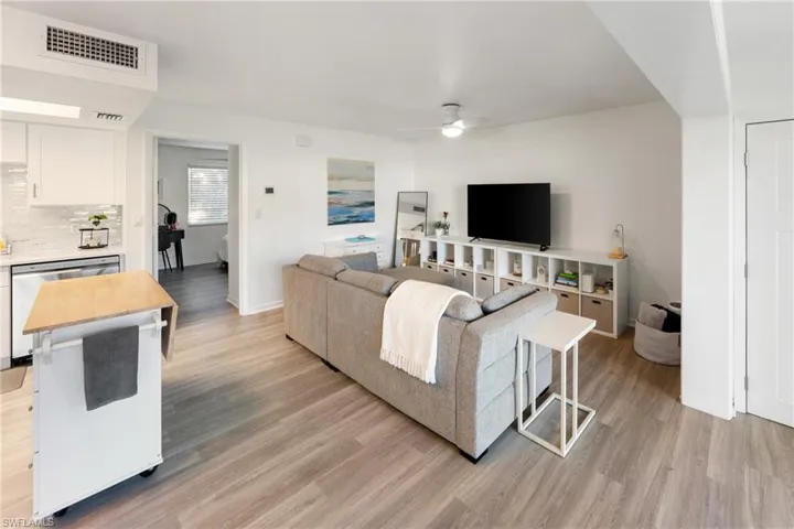 Living room with ceiling fan and light wood-style floors