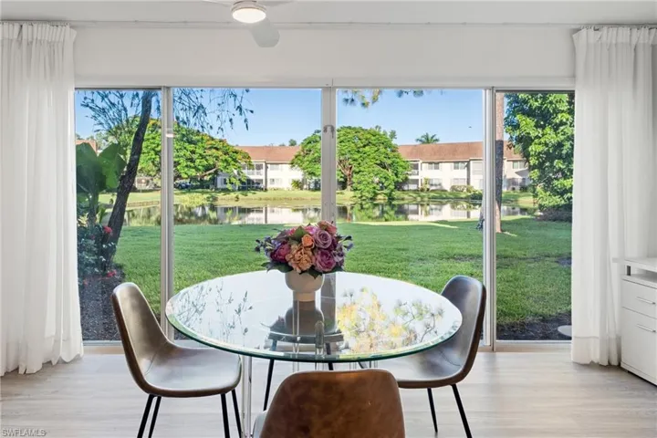 Dining area featuring light wood-style flooring, ceiling fan, and a water view