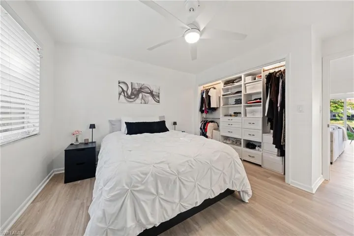 Bedroom with light wood-type flooring, ceiling fan, and a closet