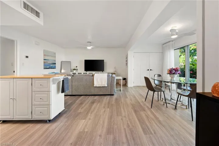 Kitchen featuring ceiling fan, white cabinets, light wood-type flooring, and wood counters