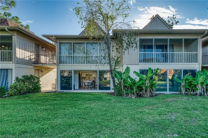 Back of property featuring a sunroom and a yard