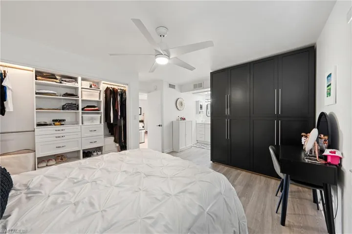 Bedroom featuring light wood-type flooring, a ceiling fan, and ensuite bath