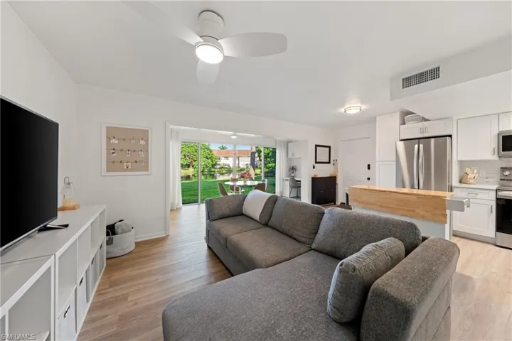Living area with light wood finished floors and a ceiling fan