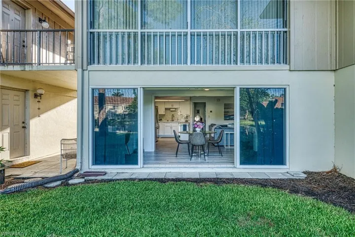 Doorway to property with stucco siding and a yard
