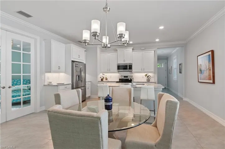 Dining room featuring crown molding, a chandelier, and light tile patterned floors