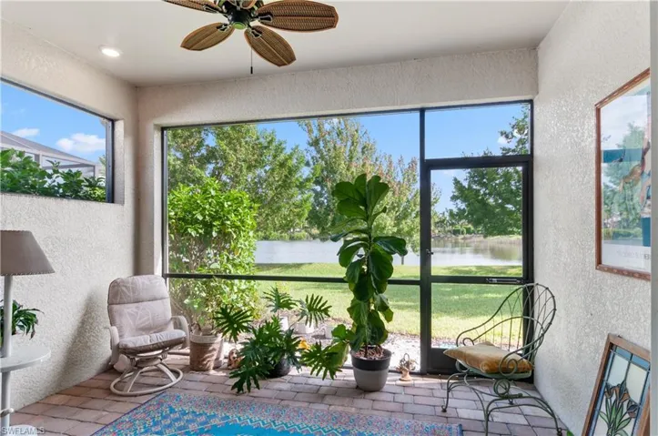 Sunroom / solarium with plenty of natural light, a water view, and ceiling fan