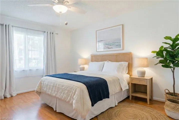 Bedroom with wood finished floors, a textured ceiling, and a ceiling fan