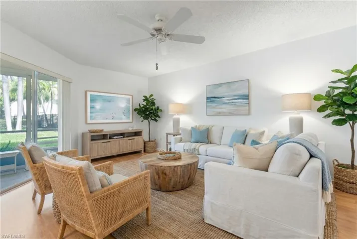 Living area with wood finished floors, a textured ceiling, and ceiling fan
