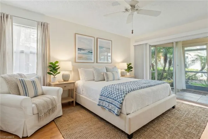 Bedroom featuring wood finished floors, a textured ceiling, ceiling fan, and access to exterior