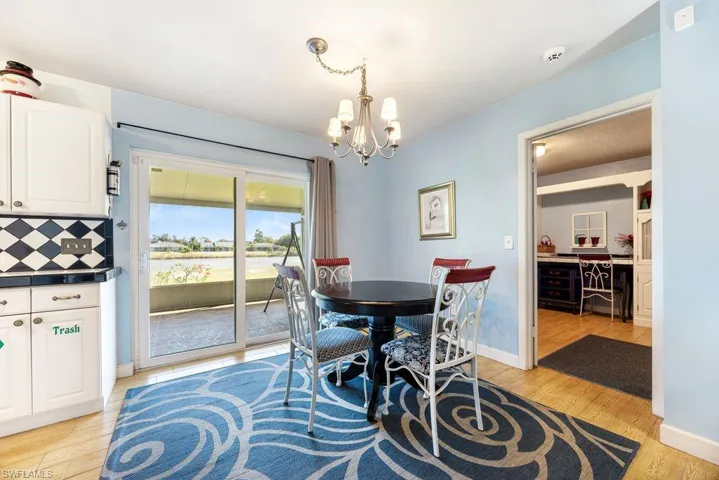 Dining area with light wood-type flooring and a chandelier