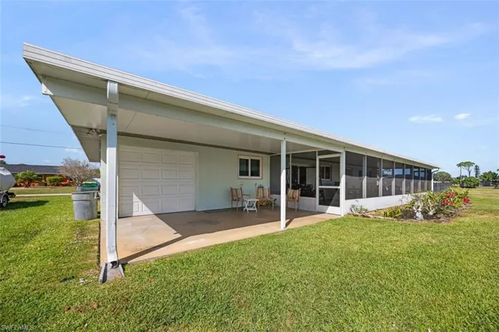 Back of property featuring a lawn, a sunroom, and an attached garage