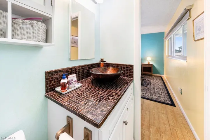 Bathroom featuring vanity, light wood-type flooring, and tasteful backsplash