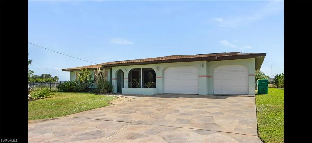 View of front of house featuring driveway, stucco siding, and an attached garage