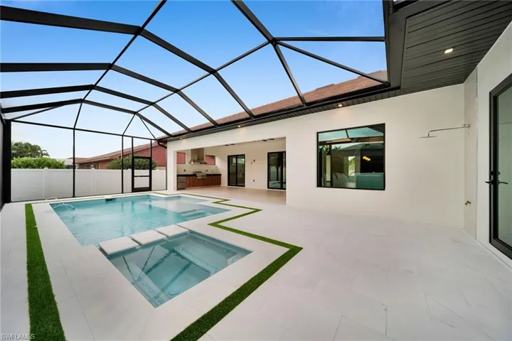 Screened patio featuring a swimming pool, integrated spa, and extensive white tile decking