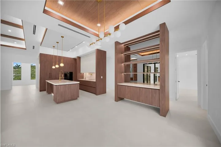 Open concept living area featuring light-toned flooring and a high ceiling with wood-finish accents