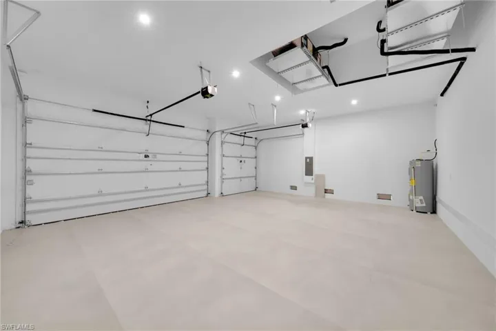 Spacious two-car garage featuring automatic openers, recessed lighting, and a neutral-toned concrete floor