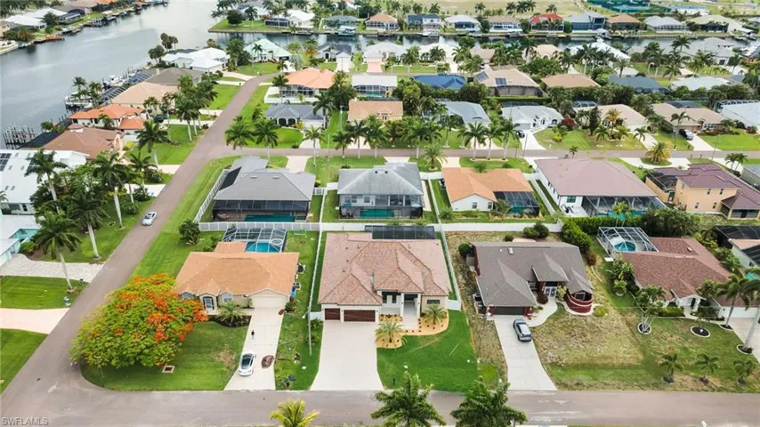 Canal-front community featuring mature palm trees and residential properties