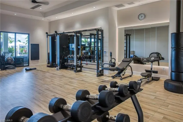 Dedicated fitness space featuring wood-finish flooring, recessed lighting, and a full-wall mirror