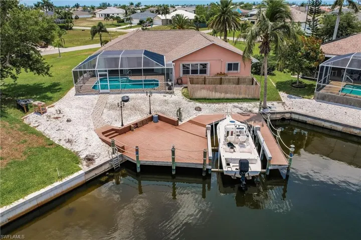 Dock area featuring a lawn, a lanai, and a water view