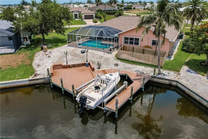 Dock area with a lanai, a water view, and a yard