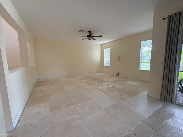 Spare room featuring a ceiling fan and baseboards