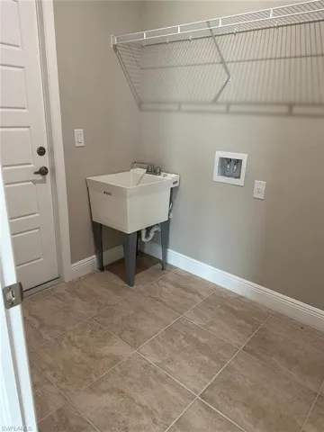 Laundry area featuring hookup for a washing machine and light tile patterned floors